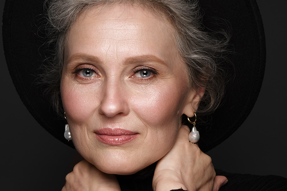 Up close of a mature woman's face wearing a black hat